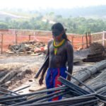 8h19: Guerreiro caminha em area desmatada, entre materiais de construção (Foto: Ruy Sposati)
